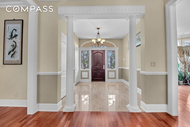 foyer featuring baseboards, a notable chandelier, and a wealth of natural light