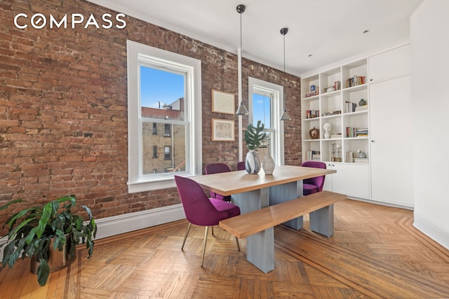 dining space with baseboards and brick wall