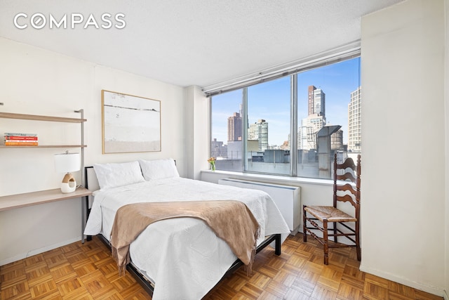 bedroom with baseboards and a city view