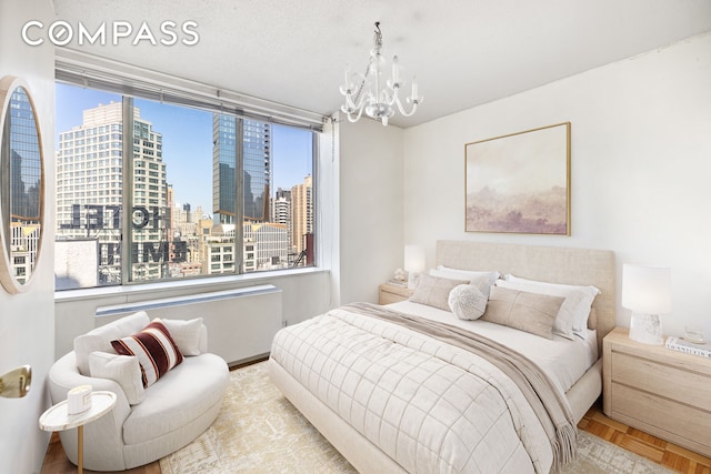 bedroom featuring a city view, a notable chandelier, and multiple windows