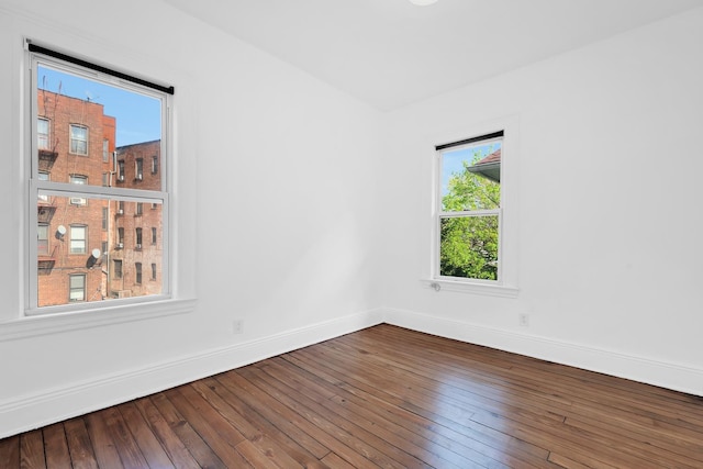 empty room with baseboards and hardwood / wood-style flooring