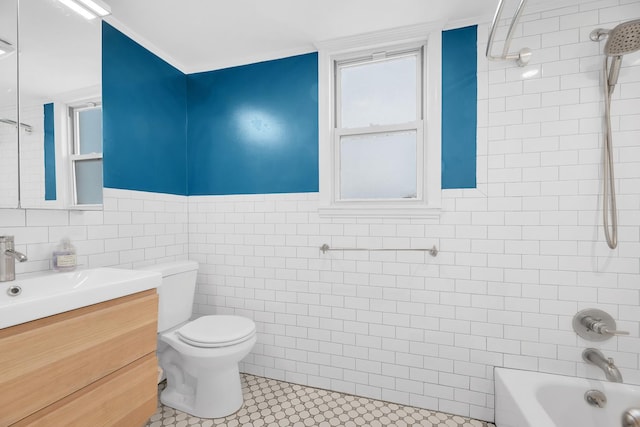 bathroom featuring tile walls, shower / tub combination, a wainscoted wall, vanity, and toilet