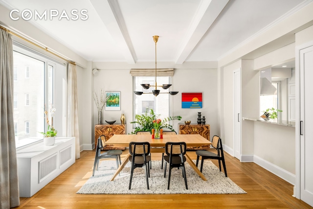 dining area featuring baseboards, a healthy amount of sunlight, and beamed ceiling