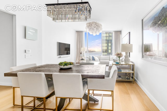 10 Riverside Blvd Unit 28C, New York City, NY 10069 - dining space with light wood-style floors, a chandelier, and baseboards