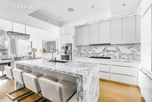 10 Riverside Blvd Unit 28C, New York City, NY 10069 - kitchen with a sink, light wood finished floors, modern cabinets, and recessed lighting
