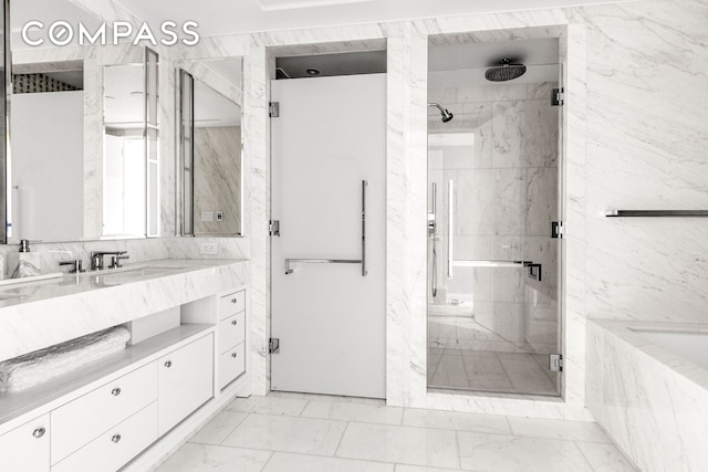 10 Riverside Blvd Unit 28C, New York City, NY 10069 - bathroom with marble look tile flooring, a marble finish shower, vanity, and a tub with marble appearance
