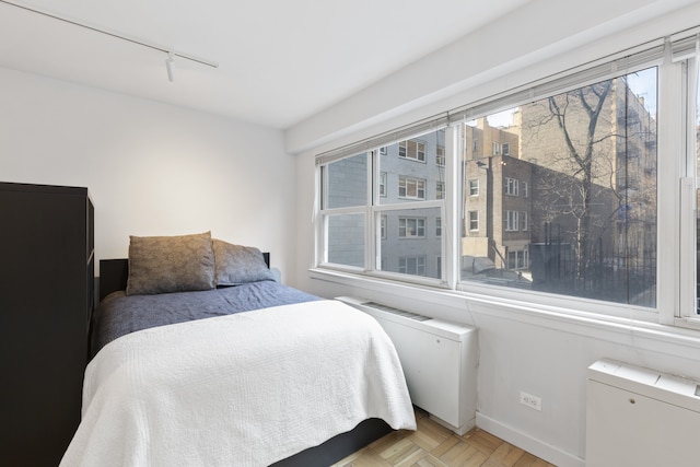 bedroom with baseboards and track lighting