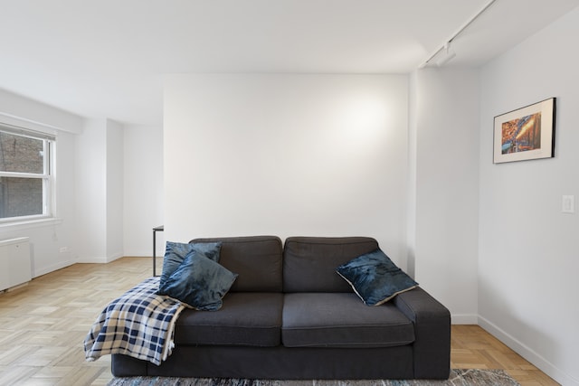 living area featuring baseboards and radiator