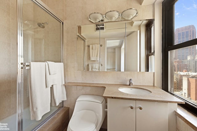 full bath with tile walls, tasteful backsplash, vanity, a city view, and toilet