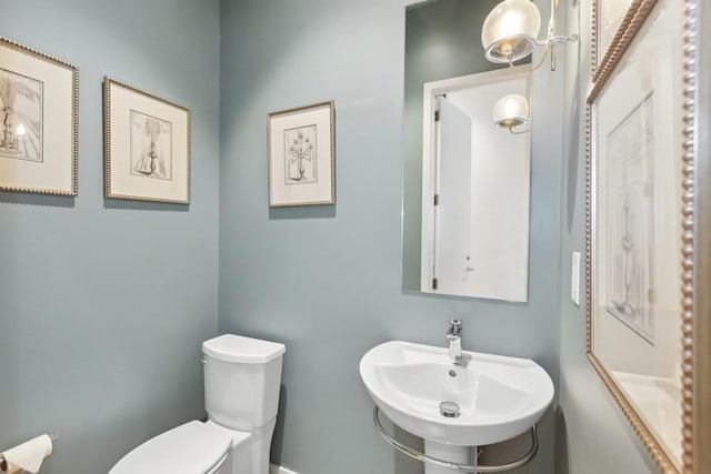 half bath with toilet and a sink