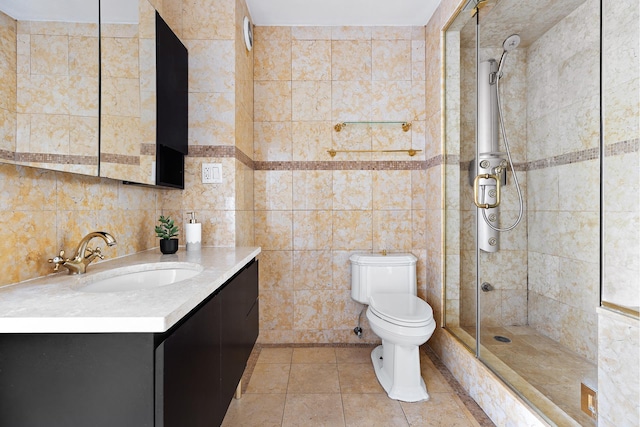 bathroom with tile walls, tile patterned flooring, a tile shower, vanity, and toilet