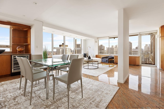 dining space featuring a city view, wine cooler, and a wall of windows