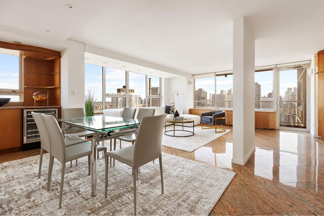 404 E 79th St Unit 28Fg, New York City, NY 10075 - dining room featuring wine cooler, a view of skyline, and floor to ceiling windows