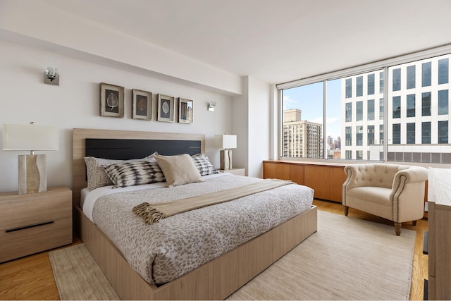 bedroom featuring a city view and light wood finished floors