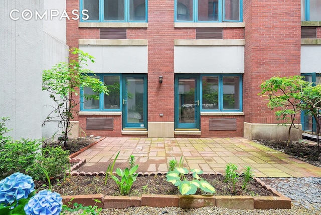 view of exterior entry featuring brick siding
