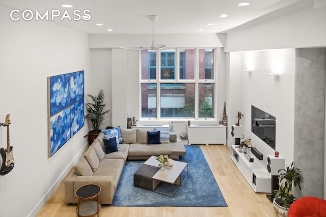 living area with recessed lighting, baseboards, and light wood finished floors