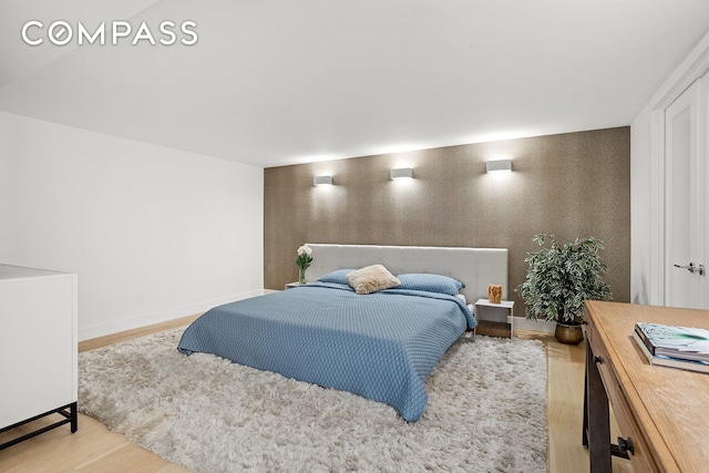 bedroom featuring baseboards and wood finished floors