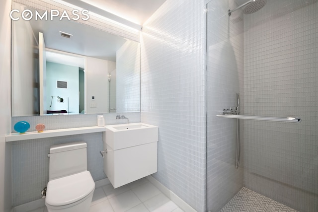 full bathroom featuring visible vents, tile patterned flooring, a tile shower, vanity, and toilet