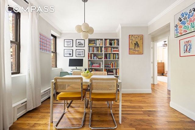 dining area featuring baseboards, ornamental molding, and wood finished floors