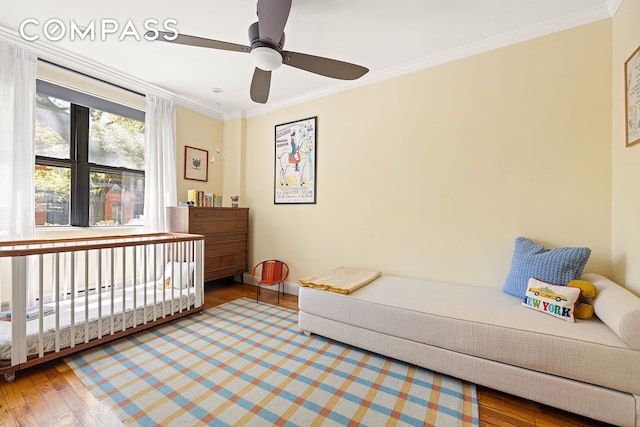 bedroom featuring crown molding, a ceiling fan, baseboards, and wood finished floors