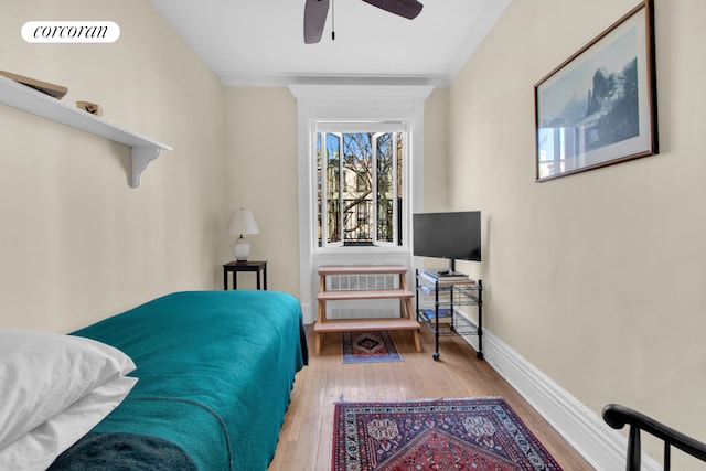 bedroom with baseboards, ceiling fan, and wood finished floors