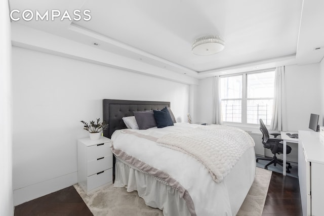 bedroom featuring light wood-style floors and a tray ceiling
