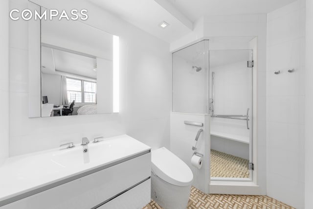 bathroom featuring vanity, toilet, a shower stall, and ensuite bath