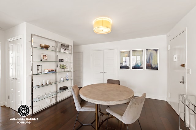 dining space with baseboards and dark wood-type flooring