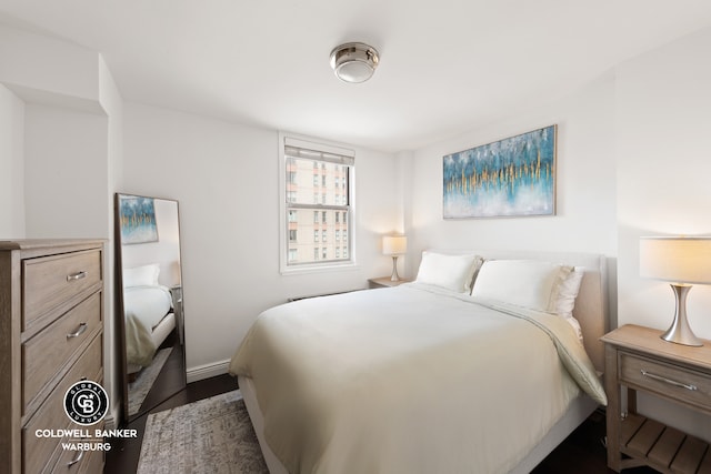 bedroom with baseboards and dark wood-style flooring