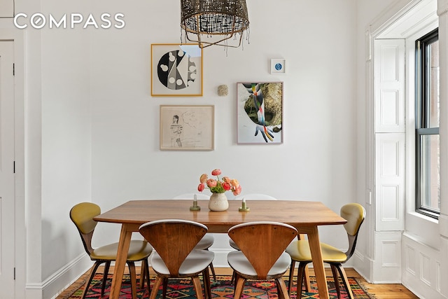 dining room featuring an inviting chandelier, baseboards, and light wood-type flooring