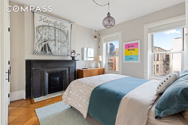 bedroom with multiple windows and a fireplace
