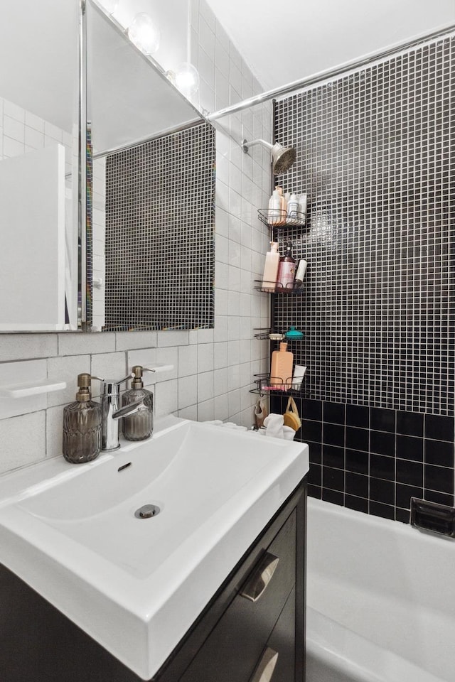 305 E 24th St Unit 4L, New York City, NY 10010 - bathroom with vanity, tasteful backsplash, shower / bath combination, and tile walls