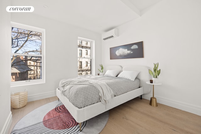 1235 Dean St Unit 5, New York City, NY 11216 - bedroom with a wall unit AC and wood finished floors