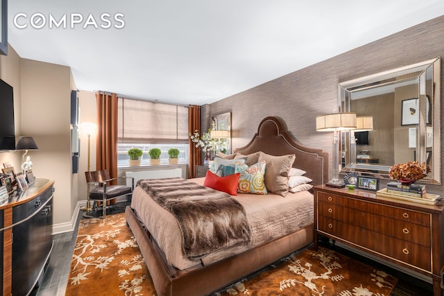 bedroom with baseboards, wallpapered walls, and dark wood-type flooring