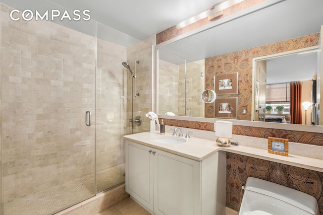 bathroom with vanity, a shower stall, and toilet