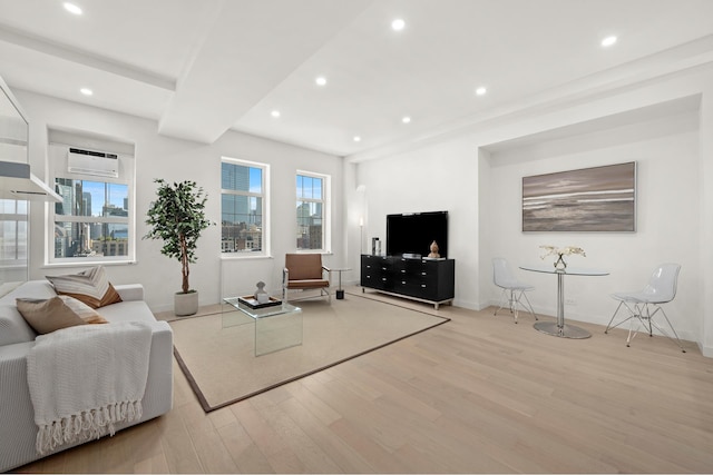 living room with light wood-type flooring, recessed lighting, an AC wall unit, and baseboards