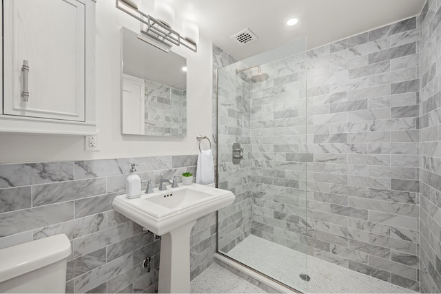 bathroom with a tile shower, tile walls, toilet, and recessed lighting