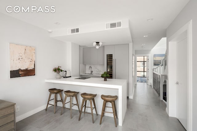 kitchen with visible vents, a peninsula, and a breakfast bar area