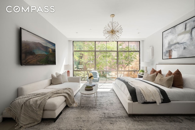 bedroom with a wall of windows, multiple windows, and a notable chandelier