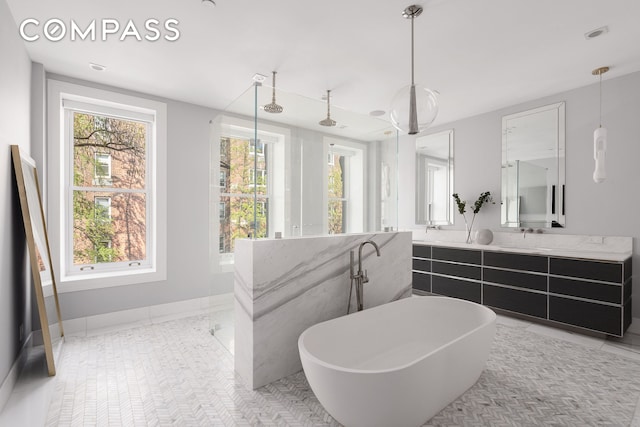 full bath with a freestanding bath, vanity, baseboards, and walk in shower
