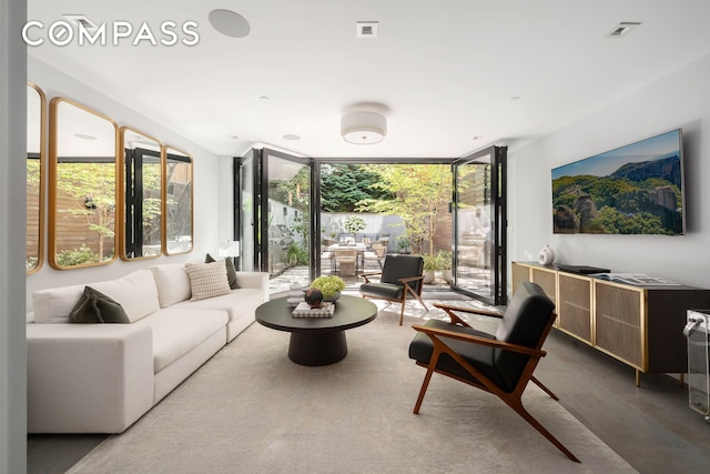 living area featuring visible vents and floor to ceiling windows