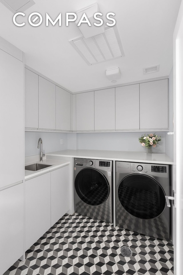 laundry area with visible vents, washing machine and dryer, cabinet space, a sink, and tile patterned floors