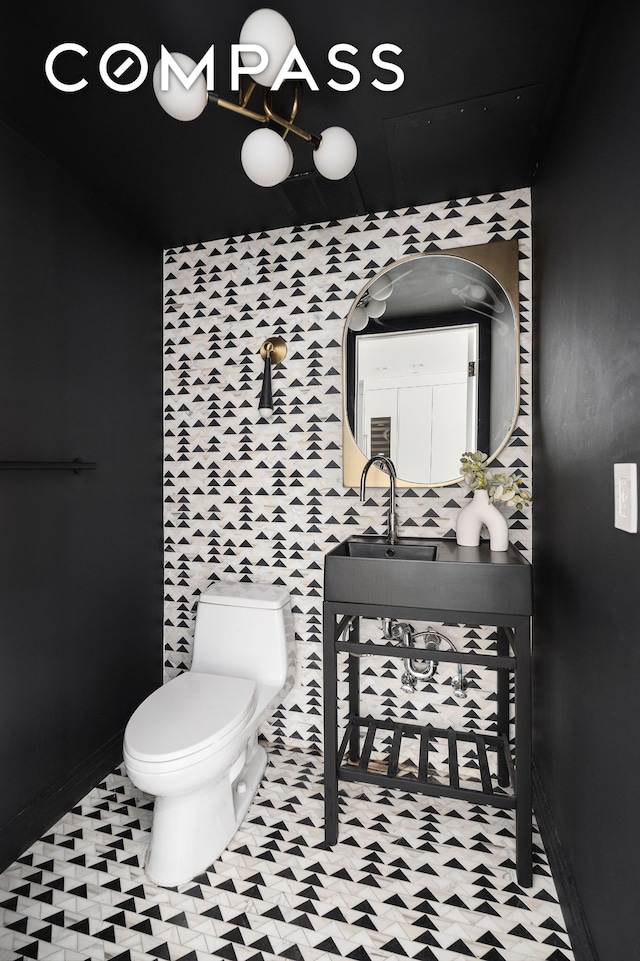 bathroom with toilet, baseboards, and a sink