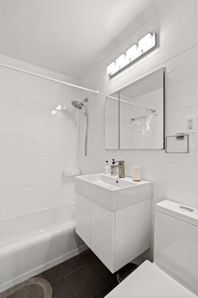 340 E 80th St Unit 17-D, New York City, NY 10075 - full bathroom with toilet, tile walls, vanity, shower / washtub combination, and backsplash
