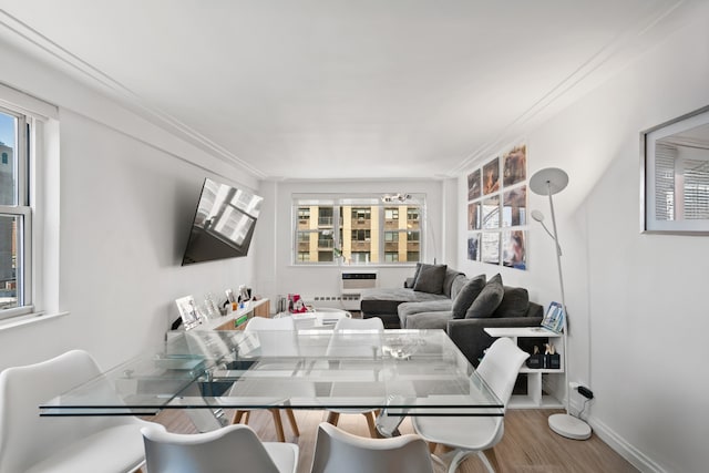 dining area with baseboards, crown molding, and wood finished floors