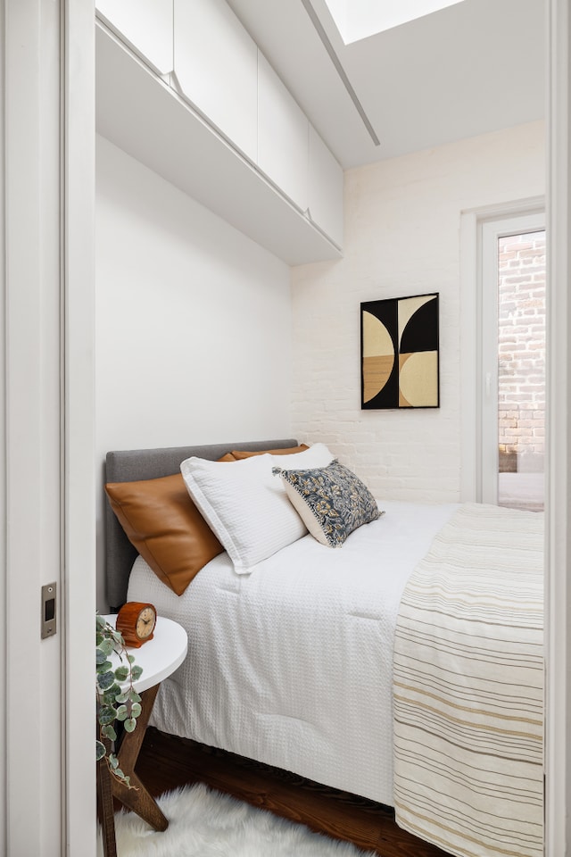bedroom featuring a skylight and wood finished floors