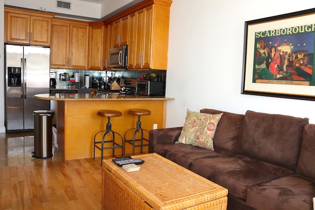 living area featuring visible vents, a toaster, and hardwood / wood-style floors