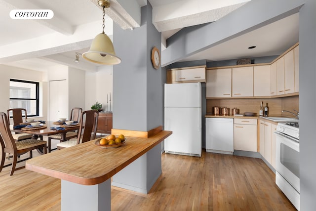 kitchen featuring tasteful backsplash, light wood-type flooring, beam ceiling, a sink, and white appliances