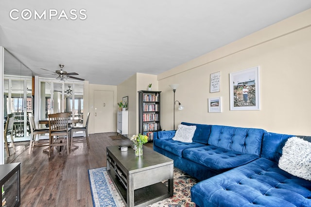 living room featuring a ceiling fan and wood finished floors