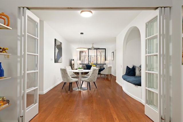 dining area with baseboards and wood finished floors